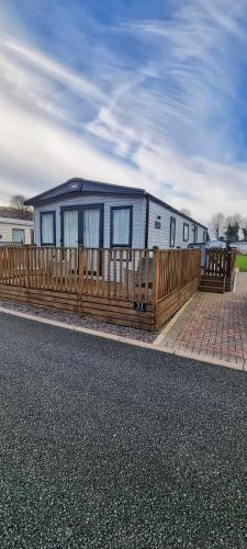 an rv is parked behind a wooden fence at Ramblers Retreat in Cockermouth