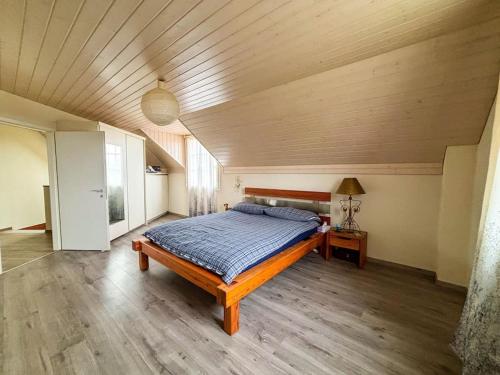 a bedroom with a bed and a wooden ceiling at Villa spacieuse et familiale in Servion