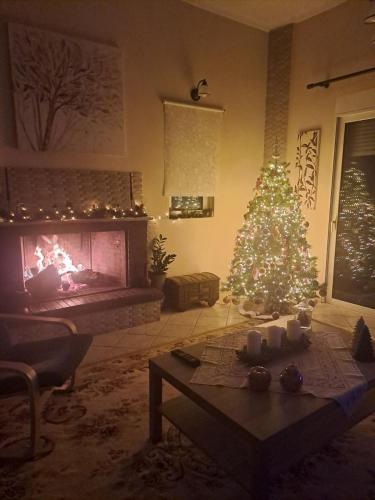 a living room with a christmas tree and a fireplace at Panorama View Aigio in Aígio