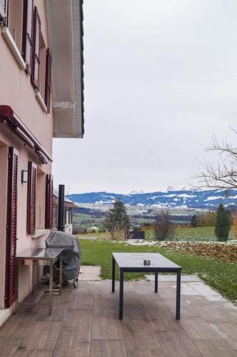 a ping pong table on a patio next to a building at Villa spacieuse et familiale in Servion