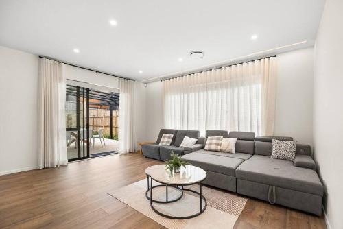 a living room with a couch and a table at Greenstead Retreat 11 beds, 8 bedrooms, 5 baths in Auckland