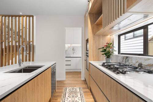 a kitchen with a sink and a stove at Greenstead Retreat 11 beds, 8 bedrooms, 5 baths in Auckland