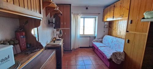 salon z kanapą i oknem w obiekcie Paradiso Aremogna w mieście Roccaraso