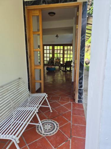 a porch with a bench sitting on a tile floor at Hotel Campestre Villa Nico in Bochalema