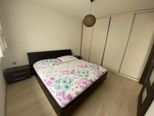 a bedroom with a bed with a floral blanket at Apartmán Hollého in Žilina