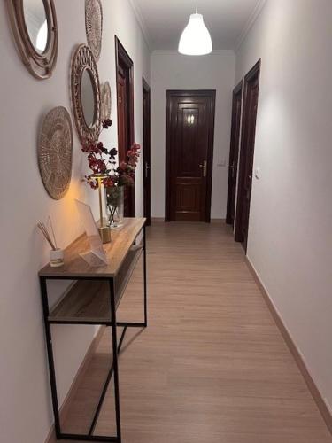 a hallway with a table with flowers and a mirror at Hostal DIMAR in Quiroga