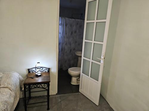 a bathroom with a toilet and a door leading to a bedroom at Casa Cachi in Mexico City