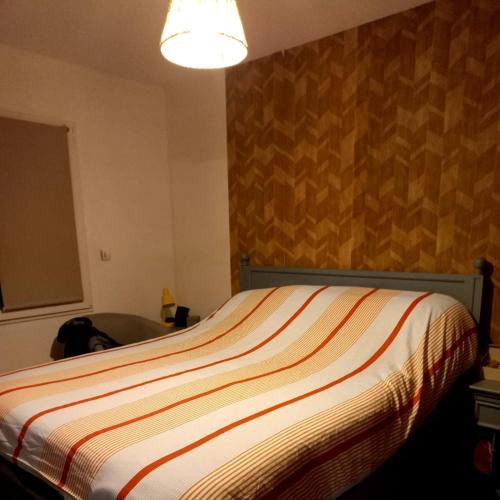 - une chambre avec un lit et une couette à rayures dans l'établissement GARNIER House, à Mulsanne