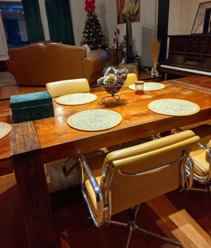 une table en bois avec des chaises et un sapin de Noël dans l'établissement GARNIER House, à Mulsanne