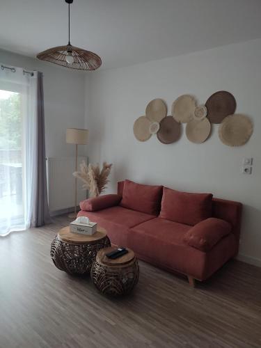 a living room with a red couch and a table at T2 en centre ville avec place de parking privative in Le Mans