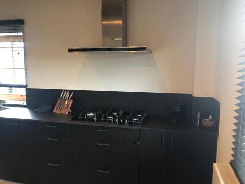 a kitchen with a black stove top in a kitchen at Le Chalet De Saint-Hubert in Saint-Hubert