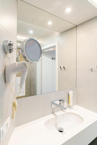 a bathroom with a mirror and a sink at Hotel Dom Zdrojowy Resort & SPA - Destigo Hotels in Jastarnia