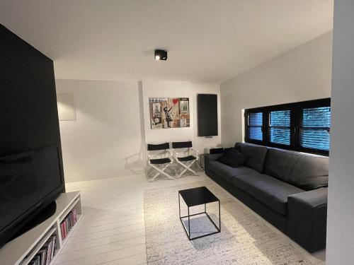 Una sala de estar con un sofá y un televisor de pantalla plana. en Appartement à proximité de Bruxelles, en Meise