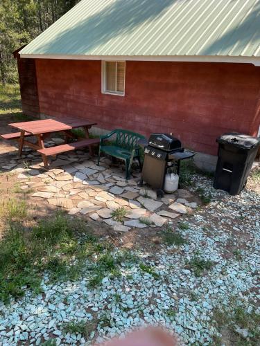 a picnic table and a grill next to a house at White Owl Retreat Yellowstone Grand Teton in Island Park