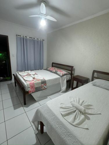 a bedroom with two beds and a ceiling fan at Pousada Marcondes in Paraty