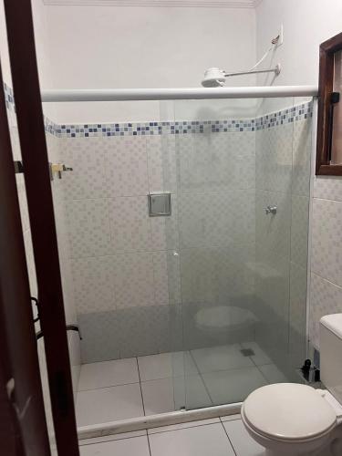 a bathroom with a glass shower with a toilet at Pousada Marcondes in Paraty