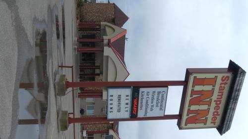 a group of signs on the side of a building at Stampeder Inn in Ponoka
