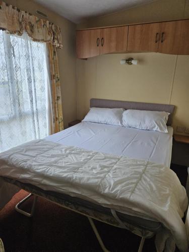 a large bed in a room with a window at Skegness North Shore Holiday Park 8 Berth 3 Bedrooms in Skegness