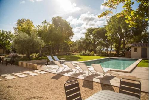 un groupe de chaises assises à côté d'une piscine dans l'établissement Villa l'Angelus - Prestigious renovated property, à Noves