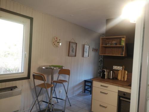 - une cuisine avec deux tabourets et une table dans l'établissement La Bresse OURSON, à La Bresse