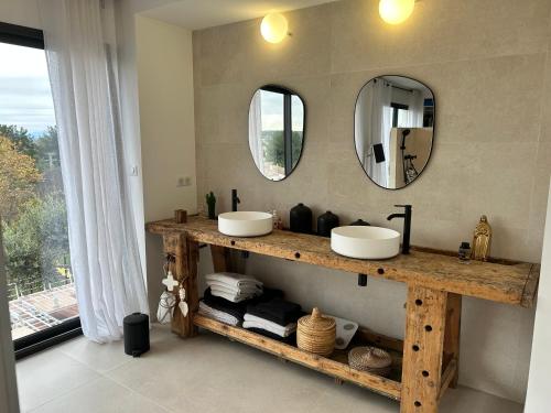 un bagno con due lavandini e due specchi di La villa sitta a Gallargues-le-Montueux