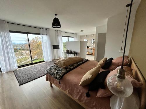 una camera da letto con un letto grande e una grande finestra di La villa sitta a Gallargues-le-Montueux