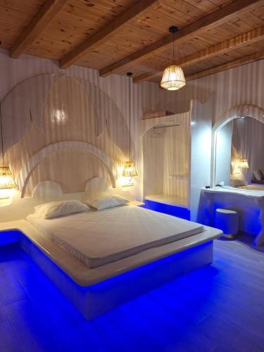 a bedroom with a large bed with blue lighting at Alta Vista Naxos in Naxos Chora
