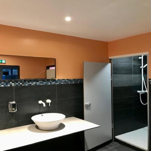 une salle de bain avec un lavabo et une douche dans l'établissement trendy hostel, à Ivry-sur-Seine