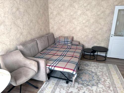 un salon avec un canapé et une chaise dans l'établissement Abay street- Tashkent city center, à Tachkent
