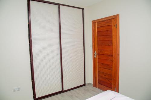 a bedroom with sliding glass doors and a wooden door at Home 458 Easy Stay in Lusaka