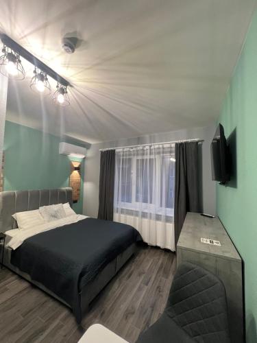 ein Schlafzimmer mit einem Bett, einem Fernseher und einer Couch in der Unterkunft Hotel Menchul in Rachiw