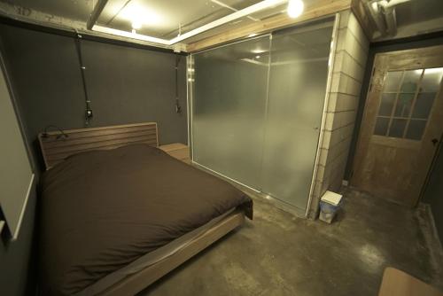 a small bedroom with a bed and a glass wall at That House Hongdae in Seoul