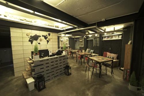 - un restaurant avec des tables et des chaises dans une salle dans l'établissement That House Hongdae, à Séoul