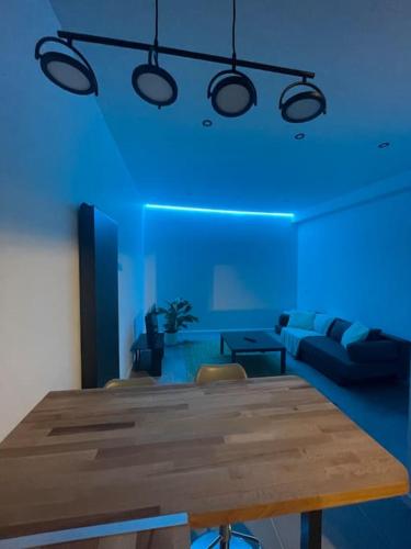 un salon avec une table en bois et un éclairage bleu dans l'établissement Maison Hyper Centre - 200 M GARE, à Tours
