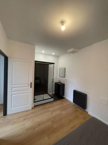 Cette chambre vide est dotée d'une porte blanche et de parquet. dans l'établissement Maison Hyper Centre - 200 M GARE, à Tours