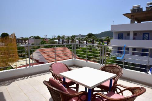 Un patio con una mesa y sillas en un balcón. en Roseberry Studios, en Faliraki