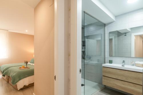 una camera da letto con un letto e un bagno con un lavandino di Apartamento en Llanes a Llanes