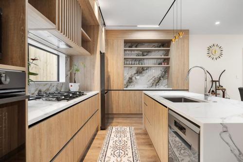 a kitchen with wooden cabinets and a stove top oven at Greenstead Retreat 11 beds, 8 bedrooms, 5 baths in Auckland