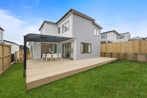a backyard with a deck with a table and chairs at Greenstead Retreat 11 beds, 8 bedrooms, 5 baths in Auckland