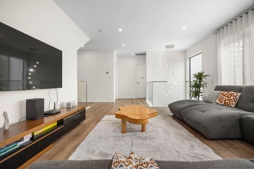 a living room with a couch and a table at Greenstead Retreat 11 beds, 8 bedrooms, 5 baths in Auckland
