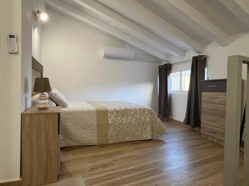 a bedroom with a bed and a wooden floor at Ca Julia in Bolulla