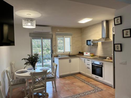 a kitchen with a table and a dining room at Ca Julia in Bolulla