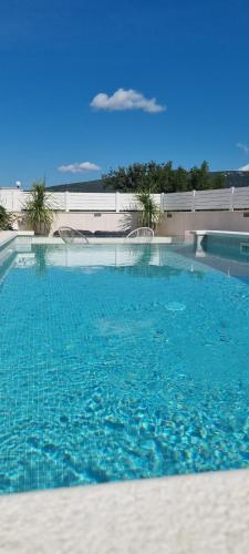 a large swimming pool with blue water at Villa Korta Regina in Ston