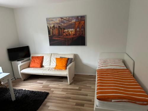 a living room with a couch and a bed at Ferienwohnung am Waldrand in Obernhain