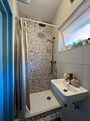a bathroom with a sink and a shower with a shower curtain at Matteotti 2 Apartment in Rovinj
