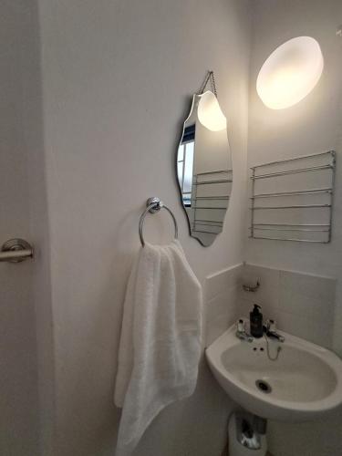 a white bathroom with a sink and a mirror at Easy Breezy at 18 Thira Santorini in Ballito