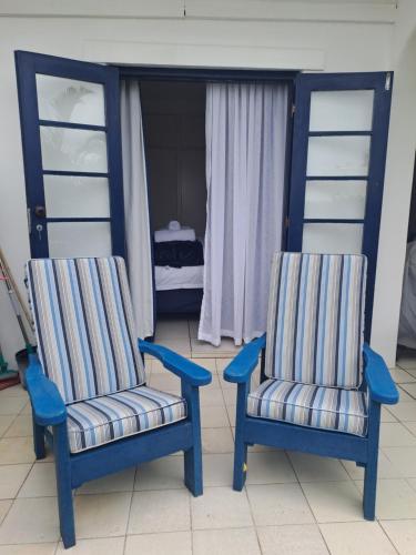 two blue chairs and a bed in a bedroom at Easy Breezy at 18 Thira Santorini in Ballito