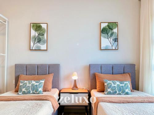 two beds sitting next to each other in a bedroom at Zeluxo #JQ02 Jesselton Quay Tower 2 Level 10-2 BR 1 Bath, Seaview in Kota Kinabalu