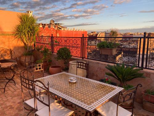 a patio with a table and chairs on a balcony at Riad le petit ksar in Meknès
