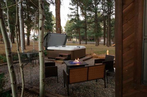 een achtertuin met een barbecue en een grill en een tv bij Mountain Home with Hot Tub in Pagosa Springs